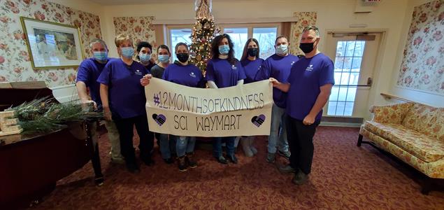 A group of SCI Waymart employees holding a banner that says #12MonthsofKindness SCI Waymart