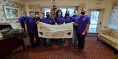 A group of SCI Waymart employees holding a banner that says #12MonthsofKindness SCI Waymart