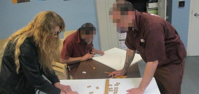 Two inmates and a DOC employee create posters