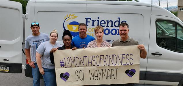 Six people hold a sign that says "#12MonthsOfKindness SCI Waymart"