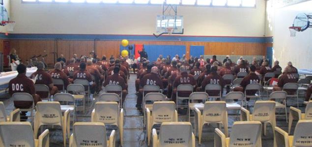 A group of inmates sitting in a gym before a reentry fair begins