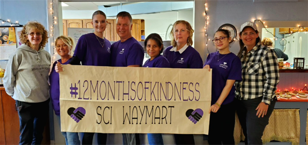 A group of people holding a sign that says "#12MonthsofKindness SCI Waymart"