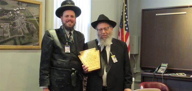 Rabbi Itkin stands with another rabbi as they hold a plaque given to Itkin for his many years of service.