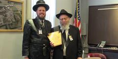 Rabbi Itkin stands with another rabbi as they hold a plaque given to Itkin for his many years of service.