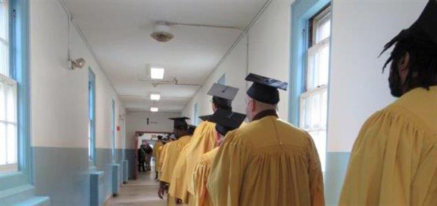Incarcerated individuals in caps and gowns walk in their processional at SCI Waymart's graduation ceremony