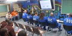 Department of Banking and Securities Outreach Specialist Becky MacDicken teaches a group of inmates at SCI Waymart.