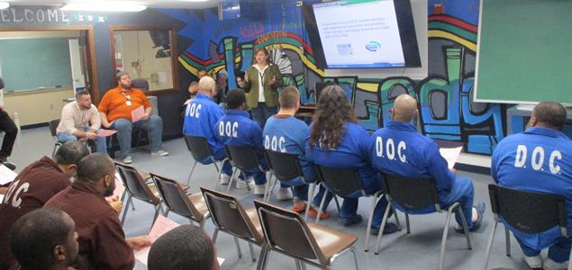 Department of Banking and Securities Outreach Specialist Becky MacDicken teaches a group of inmates at SCI Waymart.