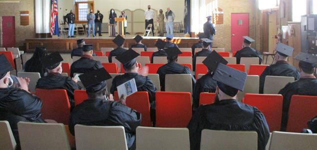 Inmate graduates sit during a ceremony