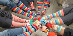 A group of people show off their brightly colored socks