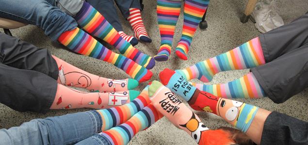 A group of people show off their brightly colored socks