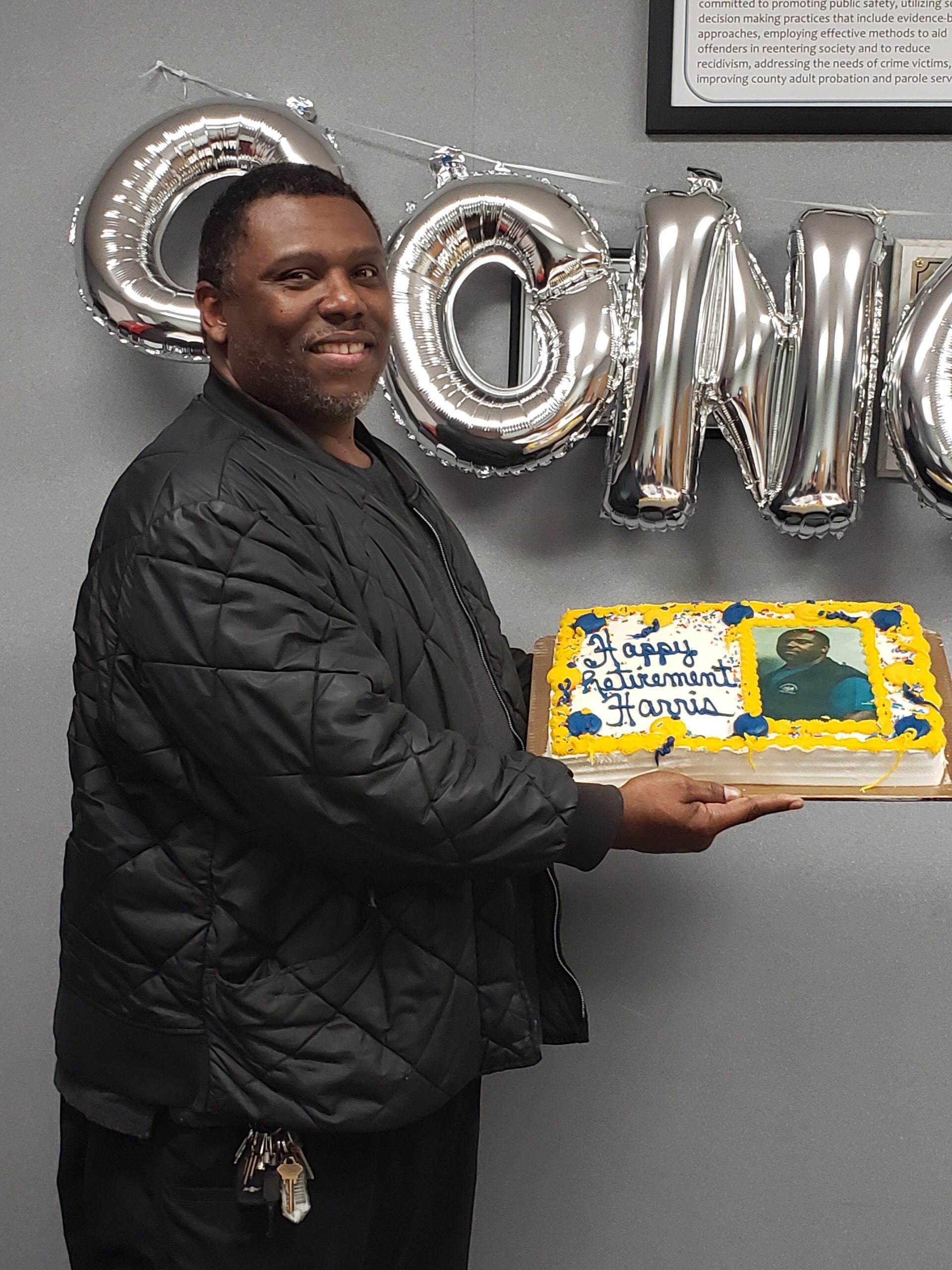 Parole agent Harris holds his retirement cake