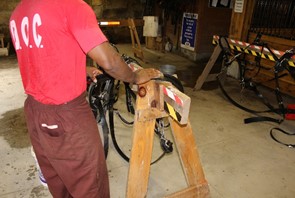 An inmate works on a bridle